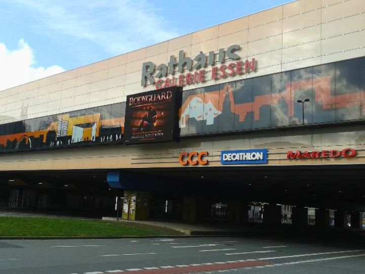 Exterior view of Rathaus Galerie Essen shopping center, featuring the building's name and promotional signage.